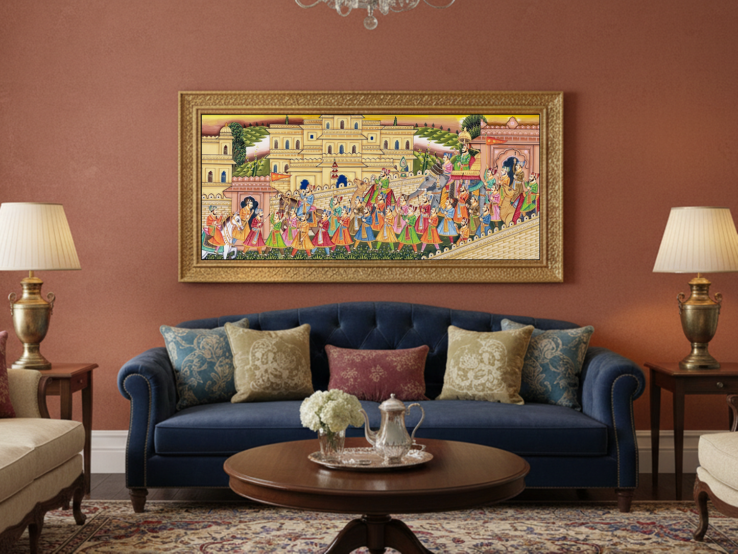 A vibrant Rajasthani painting depicting a royal procession fills a beautifully framed artwork, displayed above a stylish blue sofa with decorative pillows.