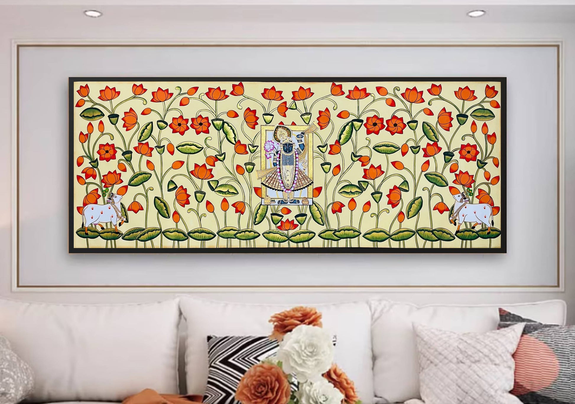 Hand-painted Pichwai painting of Shrinathji with cows and lotus flowers on a living room wall