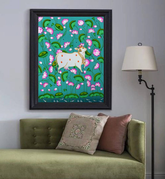 Pichwai painting of a white cow amid pink lotus flowers in a modern living room decor